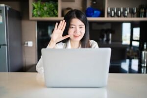 Confident Asian woman working remotely on a laptop in her modern home office, Bangkok.