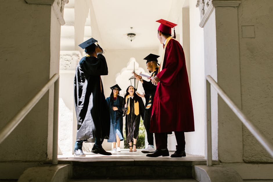 Group of diverse graduates celebrating together in a bright hallway.
